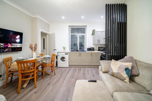 a living room with a couch and a table and a kitchen at Hayy Morley Perfect for Work or Relaxation in Leeds