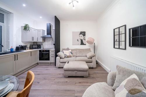 a living room with two chairs and a kitchen at Hayy Morley Perfect for Work or Relaxation in Leeds
