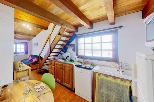 uma cozinha com um lavatório e uma mesa num quarto em CASA-La Lorraine lovely studio in a chalet St-Véran 4p 