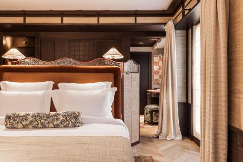 1 dormitorio con 1 cama grande con almohadas blancas en Hotel Hana en París