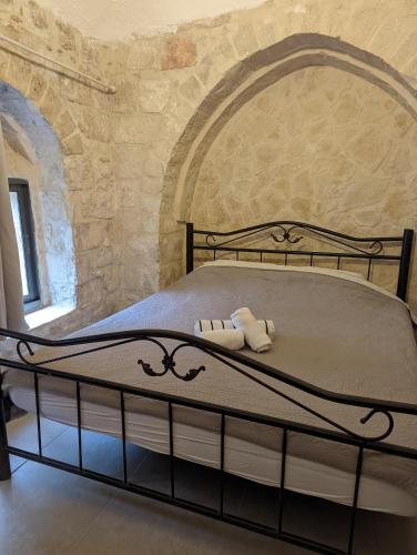 a large bed in a room with a stone wall at New Citadel Hostel in Jerusalem