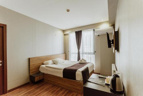 a bedroom with a bed and a desk and a window at Concept Royal Edirne in Edirne