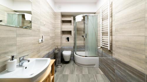 a bathroom with a sink and a shower and a toilet at Triventi Mountain Residence, Sun & Snow in Karpacz