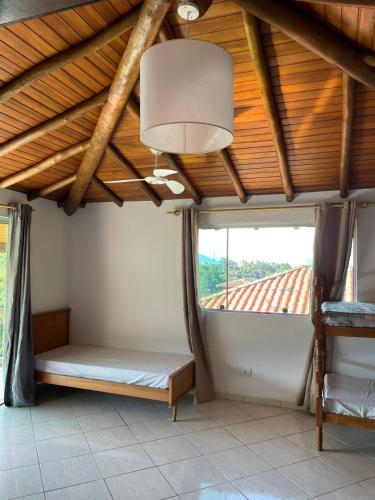 a bedroom with a bed and a large window at Chalés em Ilhabela in Ilhabela