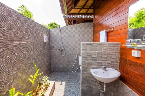 uma casa de banho com um lavatório e um chuveiro em Maharatu Villa Lembongan em Nusa Lembongan