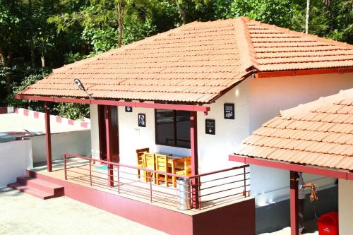 a small white house with a red roof at The Brown and Brew Homestay in Chikmagalūr