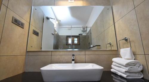 y baño con lavabo blanco y espejo. en Chembra Adobe Pattanimala Kerala, en Kalpetta