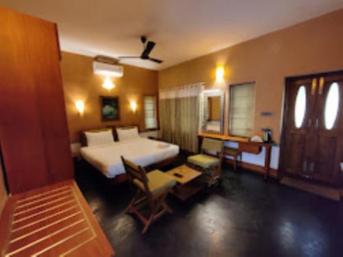1 dormitorio con 1 cama blanca grande y escritorio en Chembra Adobe Pattanimala Kerala, en Kalpetta