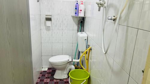 uma casa de banho com um WC e um balde verde em Pangkor 48 HomeStay em Pangkor