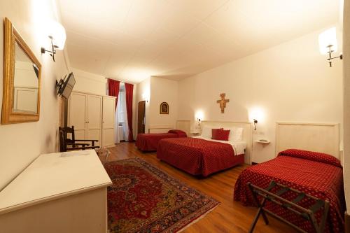 sypialnia z 2 łóżkami i krzyżem na ścianie w obiekcie Hotel Pax w Asyżu