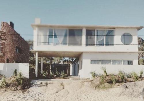 a white house on the beach next to the sand at Malujoseignacio in José Ignacio