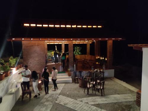 a group of people walking into a building at night at The Brown and Brew Homestay in Chikmagalūr