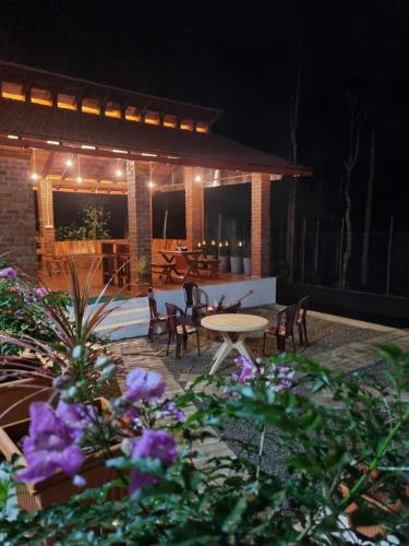 a patio with a table and chairs at night at The Brown and Brew Homestay in Chikmagalūr