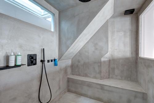 a shower with a hose in a bathroom with a window at Pretty Parisian Penthouse in Paris