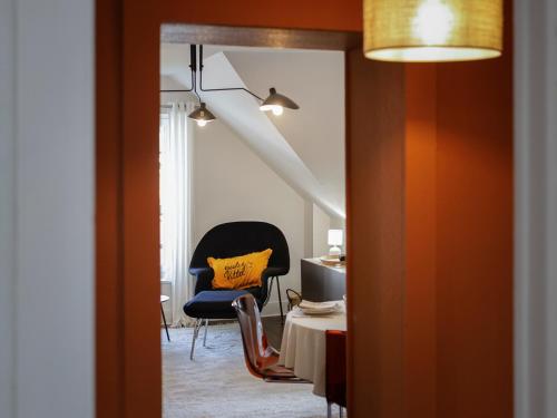Habitación con silla, mesa y almohada amarilla en Calme, Confort et Propreté, en Vittel