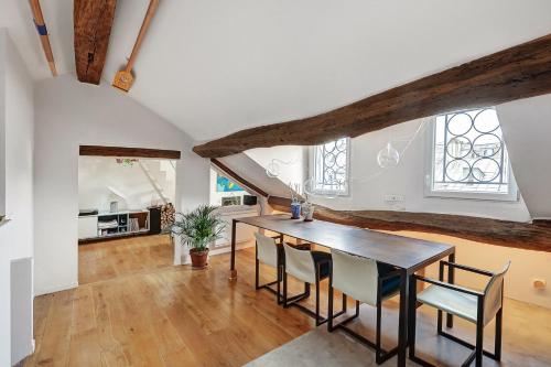 une salle à manger avec une table et des chaises dans l'établissement Pretty Parisian Penthouse, à Paris