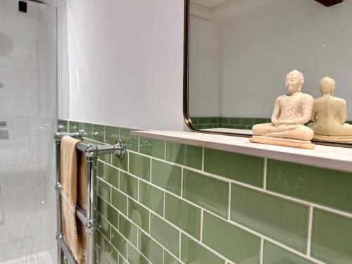 a bathroom with a mirror and two statues on a shelf at Cathedral Views Period Townhouse w/ Free Parking in Salisbury