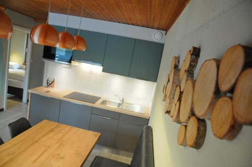 a kitchen with a table and wooden plates on the wall at Maison du Lac 14 in Vielsalm