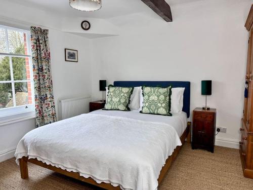 a bedroom with a large bed and a window at Cathedral Views Period Townhouse w/ Free Parking in Salisbury