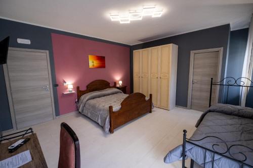a bedroom with a bed with purple walls and a table at Room 112 Oltremare in Bagheria