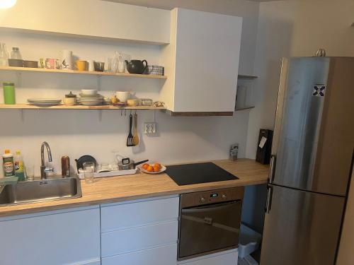 a kitchen with a stainless steel refrigerator and a sink at Ved sjøkanten, Ålesundsvegen 1068 in Ålesund