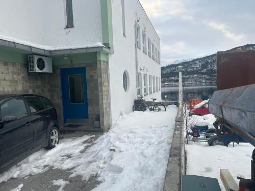 a car parked outside of a building in the snow at Ved sjøkanten, Ålesundsvegen 1068 in Ålesund