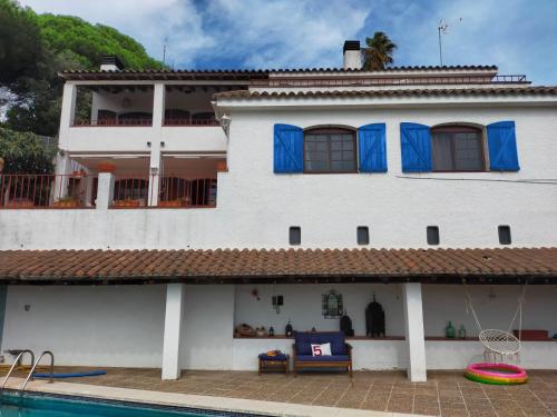 une maison blanche avec une piscine en face de celle-ci dans l'établissement Villa Alella, à Alella