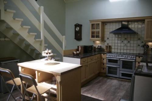 a kitchen with a counter with chairs and stairs at Easter Ellister in Port Charlotte