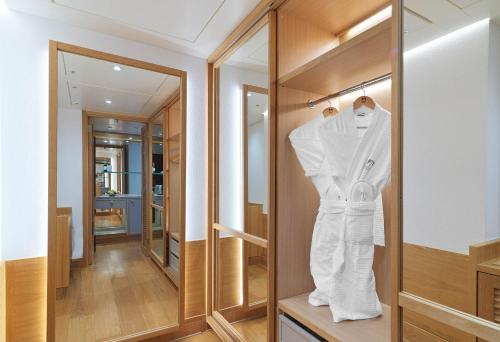 a dressing room with a white robe hanging on a closet at Columbia Beach Resort in Pissouri