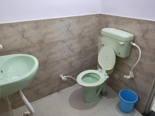 a bathroom with a green toilet and a sink at Hotel Vrindavan Ratnagiri in Ratnagiri