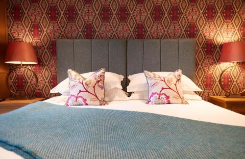 um quarto com uma cama com duas almofadas em Cumbria Holiday Apartment Ainstable em Ainstable