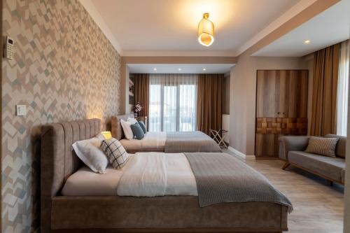 a hotel room with two beds and a couch at Lagun Palas in Yalova