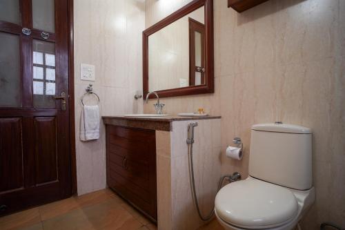 a bathroom with a toilet and a sink and a mirror at SaffronStays The Perch in Kasauli