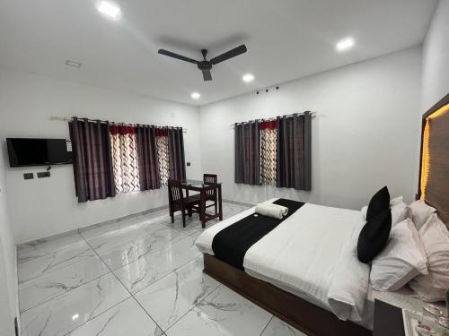 a bedroom with a bed and a table and a chair at Mount court munnar in Munnar