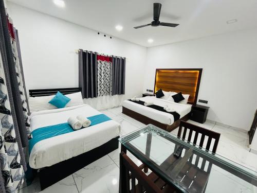 a hotel room with two beds and a glass table at Mount court munnar in Munnar