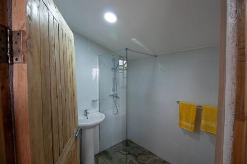 a bathroom with a shower and a sink at Elwai Centre Wood Cabins - Couples' hideout in Heni Village
