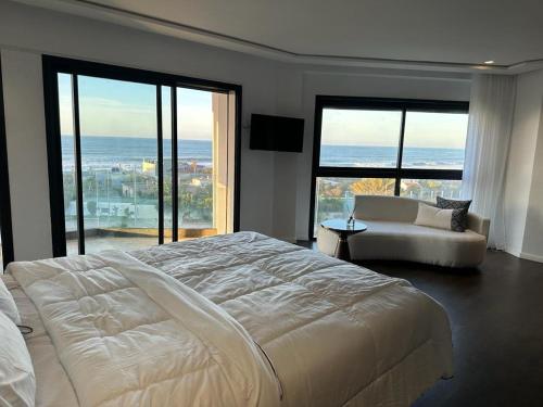 a bedroom with a large bed and a view of the ocean at Luxury Villa Jack Beach Resort Ocean Oasis View Panoramic in Casablanca
