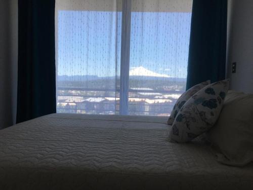 Llit o llits en una habitació de Depto hermosa vista al Lago y Volcán