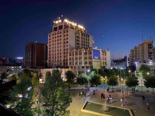 a large building with lights on top of it at night at The Grey Apartment - Center of Prishtina in Pristina