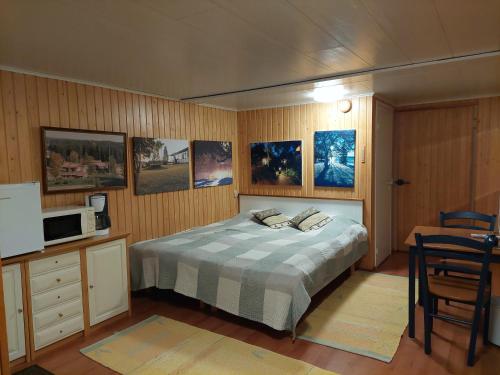 ein Schlafzimmer mit einem Bett und einige Bilder an der Wand in der Unterkunft Saunamaailman Kivari 1 ja 2 