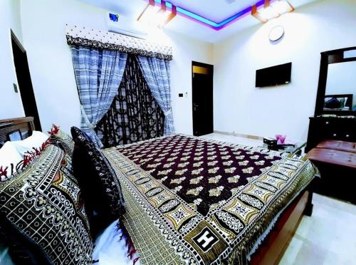 a bedroom with a large bed with a blanket at Galaxy Inn Guest House in Karachi
