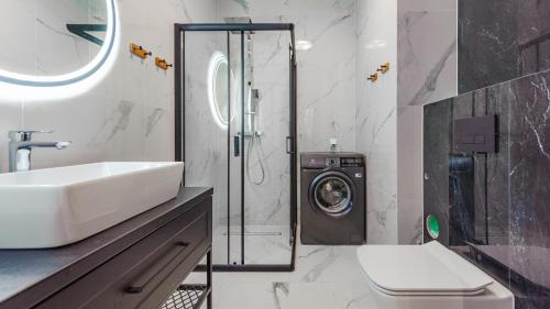 a bathroom with a sink and a washing machine at Apartamenty Sun & Snow Belnihel in Hel