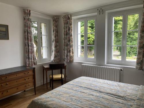a bedroom with a bed and two windows and a desk at LIf in Varengeville-sur-Mer