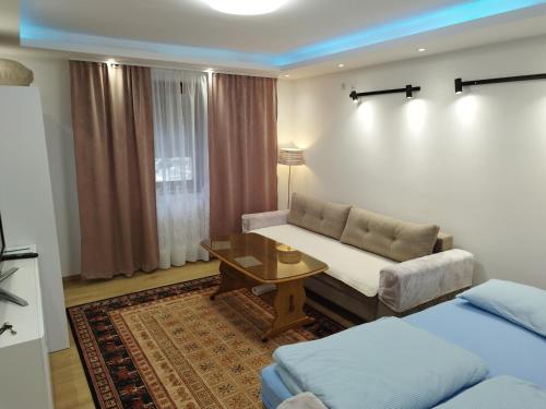 un soggiorno con divano e tavolo di Villa Amer Lux Apartments a Sarajevo