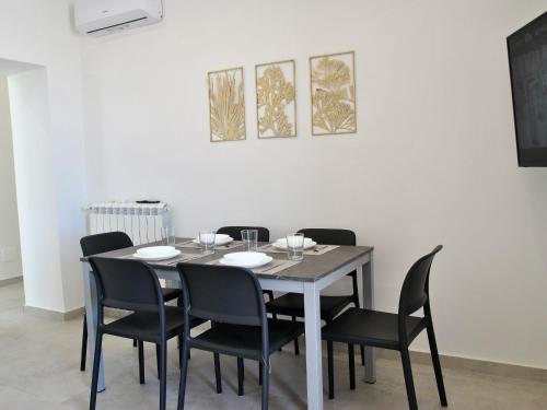 a dining room table with black chairs and a white wall at Apartment Brezza di Mare by Interhome in Formia