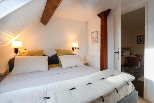 1 dormitorio con 1 cama blanca grande y 2 almohadas en Calme, Confort et Propreté, en Vittel