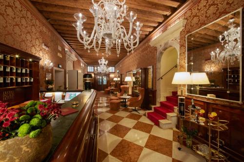 a hotel lobby with a chandelier and a checkerboard floor at Duodo Palace in Venice