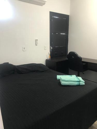 a bedroom with a bed with two towels on it at HOUSE DORA AP 03 com AR CONDICIONADO in Campo Grande