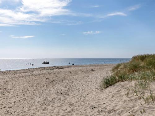 une plage de sable avec l'océan en arrière-plan dans l'établissement Holiday Home Solfred - 200m from the sea in Bornholm by Interhome, à Vester Sømarken