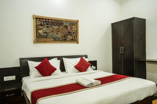 - une chambre dotée d'un grand lit avec des oreillers rouges et blancs dans l'établissement Deluxe gujrat hotel, à Jaisalmer